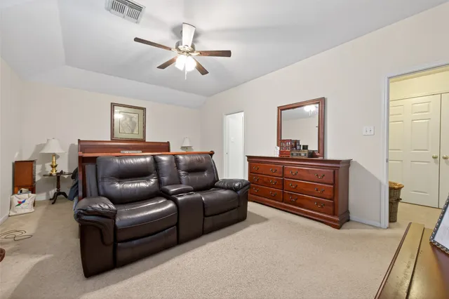 a living room with furniture and a ceiling fan