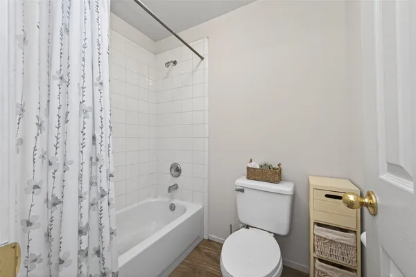 a white toilet sitting next to a bath tub