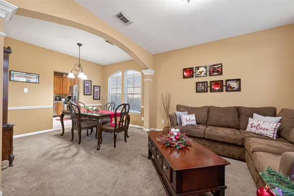 a living room with furniture and a dining table