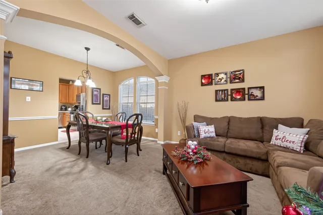 a living room with furniture and a dining table