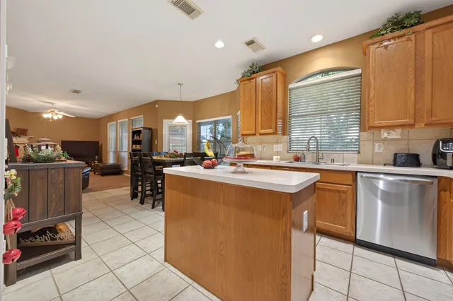 a kitchen with stainless steel appliances granite countertop a sink a stove and a refrigerator