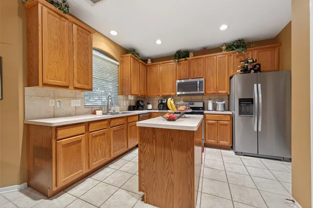 a kitchen with granite countertop a refrigerator and a sink