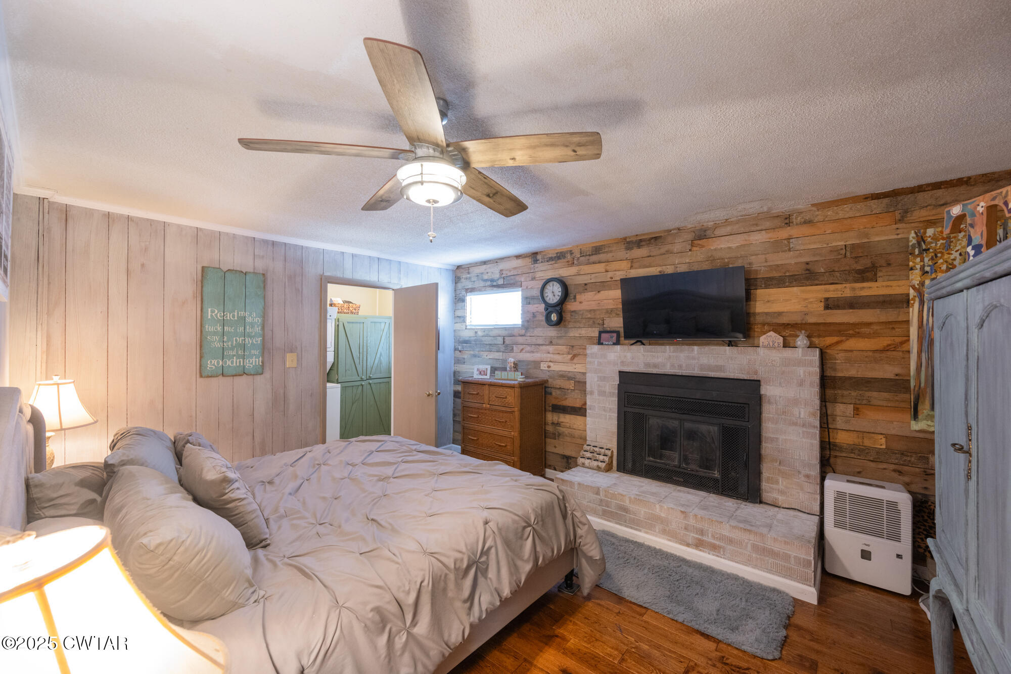 982 Lost Creek Boat Dock Road Decaturville, TN 38329 - Photo 16 of 31 a spacious bedroom with a bed and a fireplace