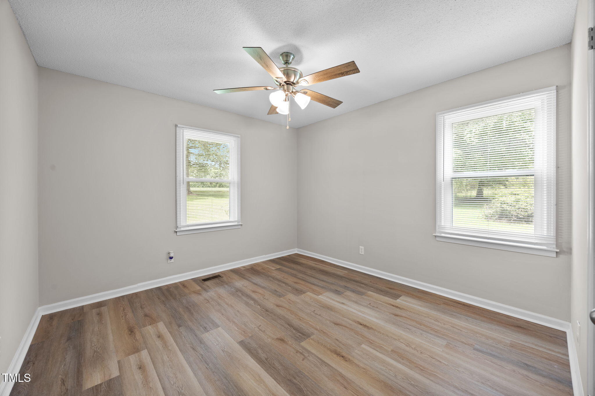 1050 Rock Spring Church Road Henderson, NC 27537 - Photo 10 of 24 an empty room with wooden floor windows and fan