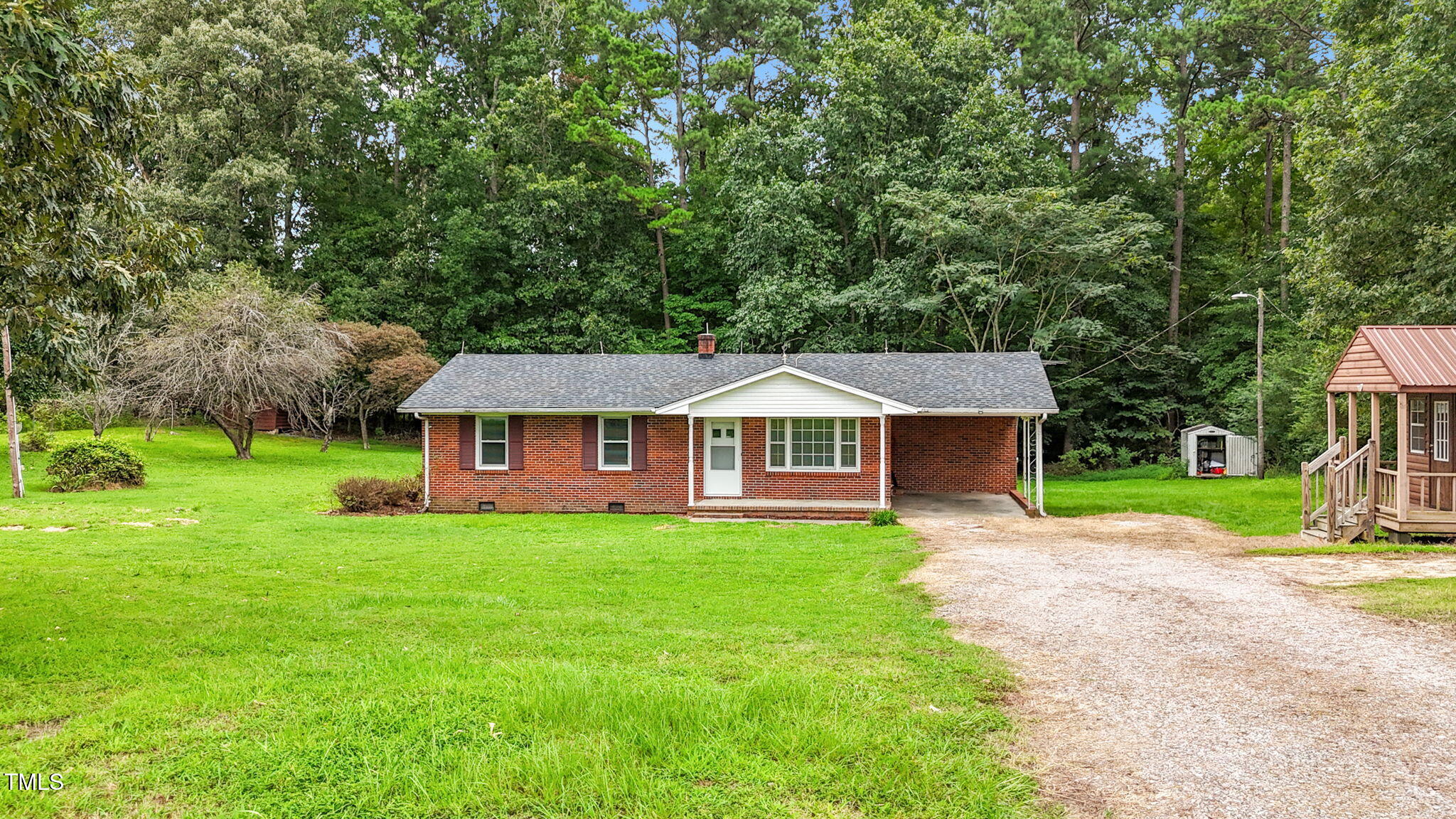 1050 Rock Spring Church Road Henderson, NC 27537 - Photo 21 of 24 a view of a house with a big yard potted plants and large tree