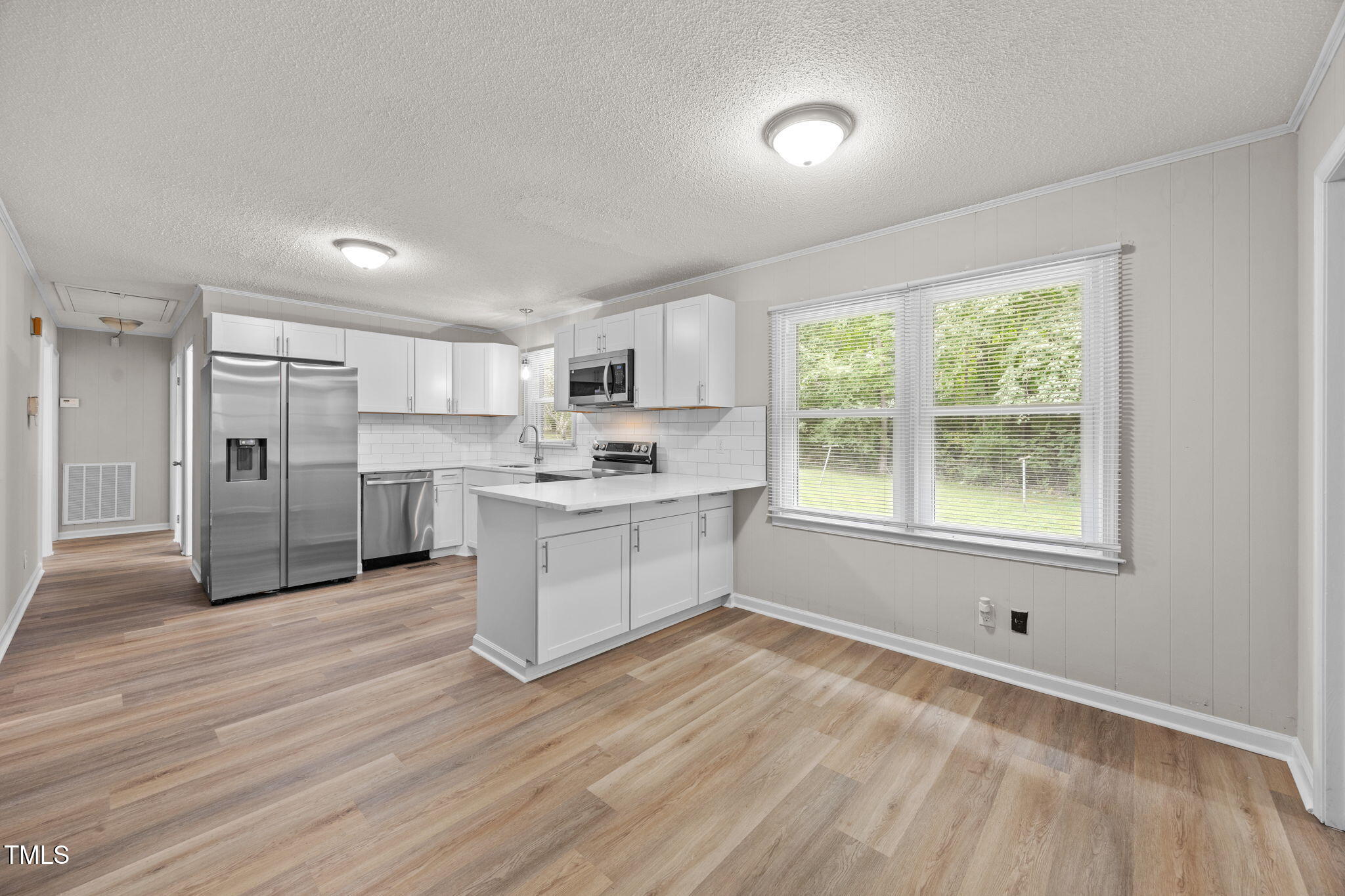 1050 Rock Spring Church Road Henderson, NC 27537 - Photo 4 of 24 a kitchen with white cabinets and window