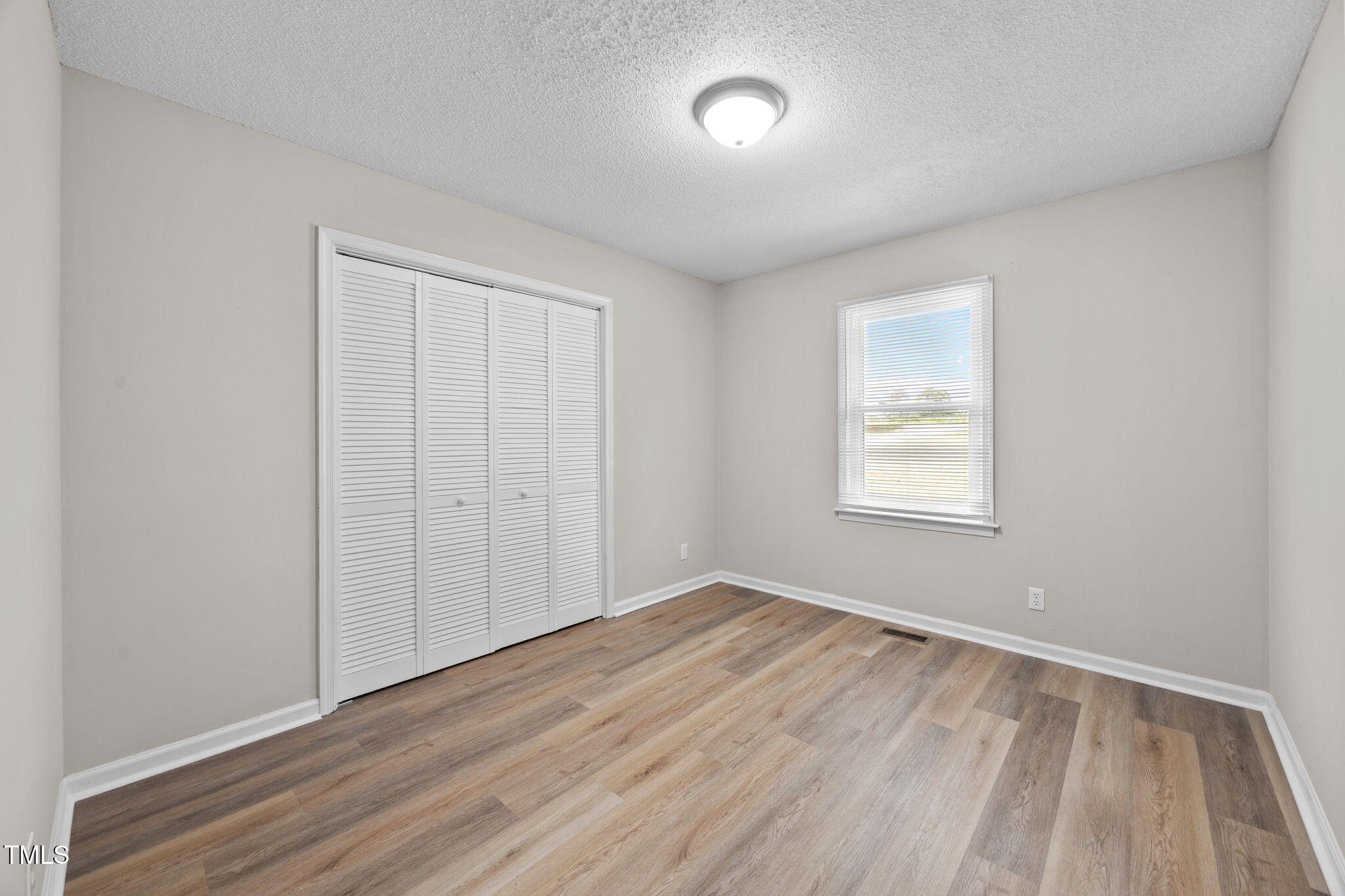 1050 Rock Spring Church Road Henderson, NC 27537 - Photo 9 of 24 an empty room with wooden floor and windows