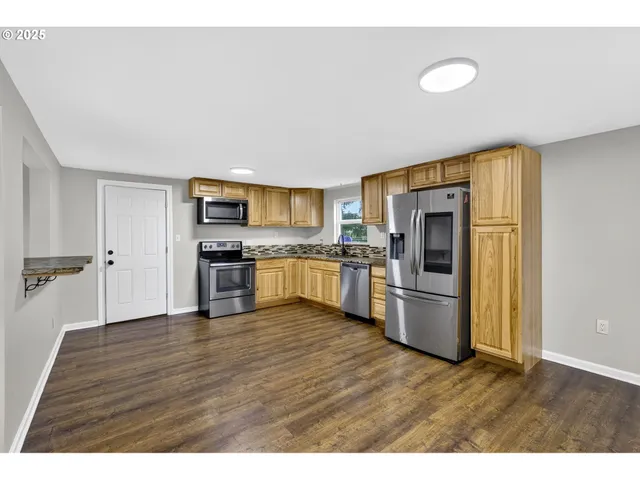 a kitchen with stainless steel appliances a refrigerator and a stove top oven