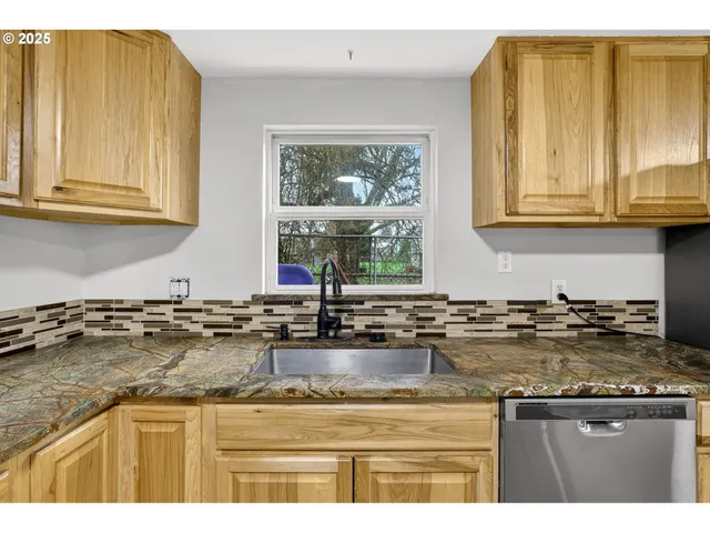 a kitchen with granite countertop a sink and a window