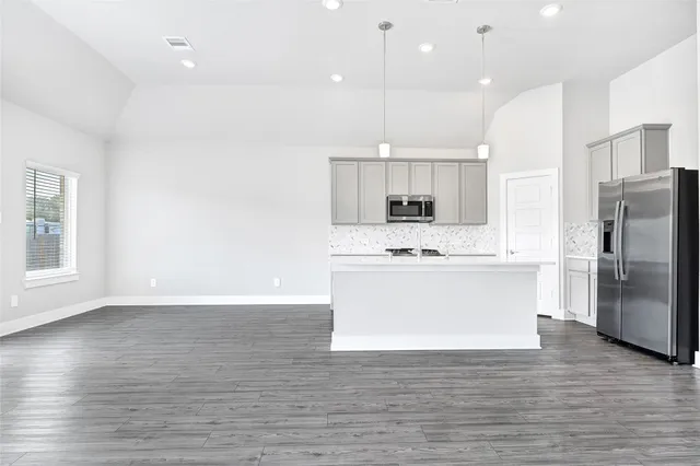 a view of kitchen with kitchen island white cabinets stainless steel appliances and center island