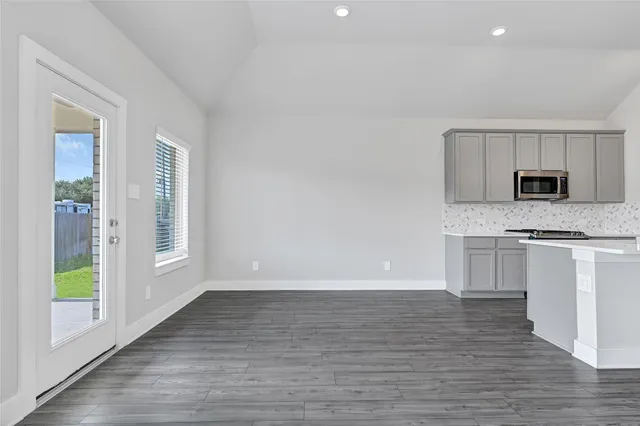 a view of kitchen with granite countertop cabinets and window