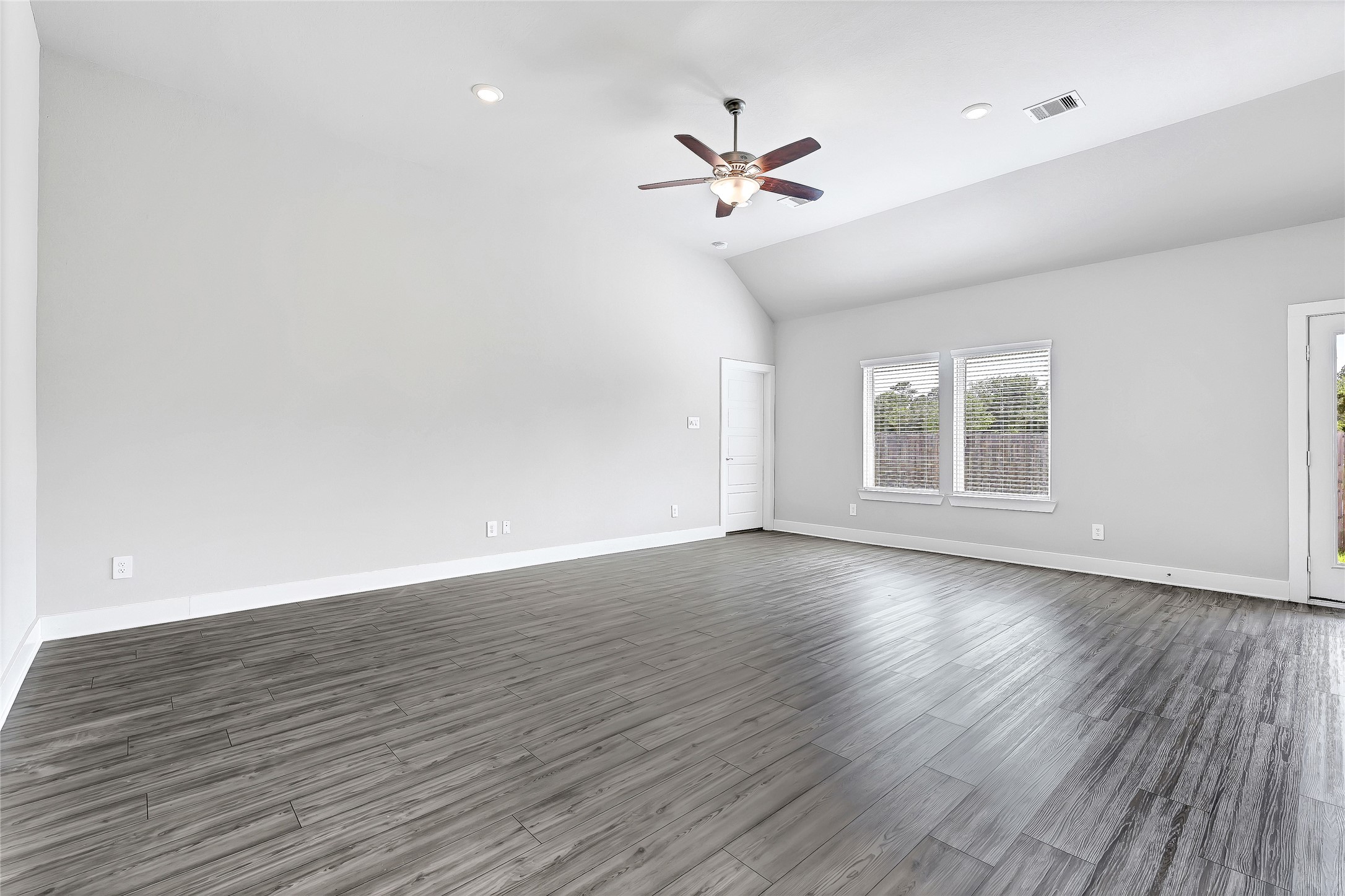 10329 South Goshawk Trail Conroe, TX 77385 - Photo 17 of 46 a view of an empty room with wooden floor and a window