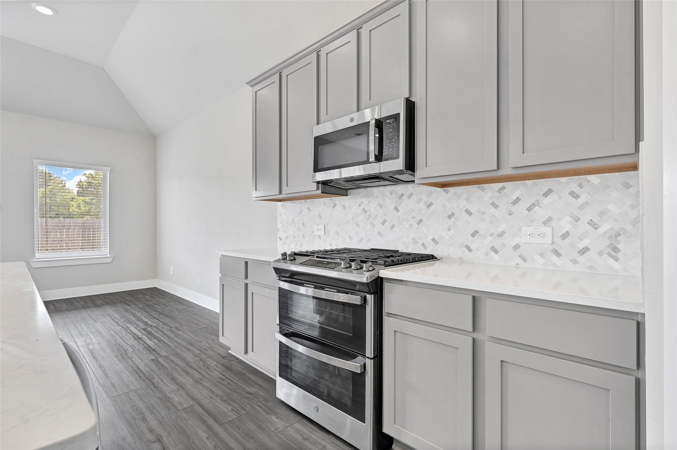 10329 South Goshawk Trail Conroe, TX 77385 - Photo 10 of 46 a kitchen with stainless steel appliances white cabinets and a stove top oven