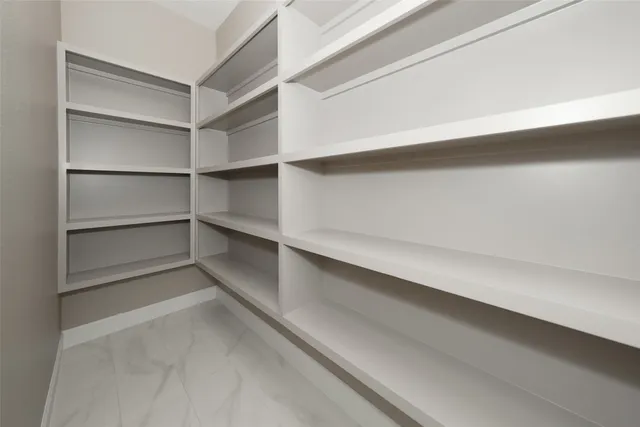 a view of walk in closet with empty racks