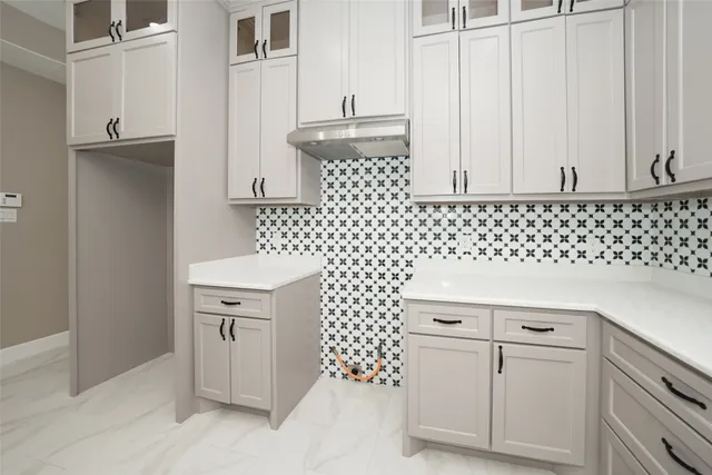 a large white kitchen with a large window