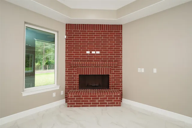 an empty room with chandelier fan and windows