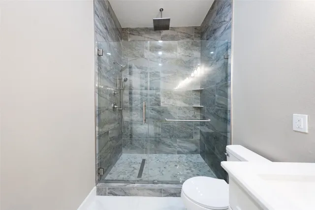 a bathroom with a double vanity sink toilet and shower