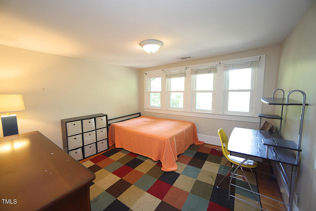 3409 White Oak Road Raleigh, NC 27609 - Photo 17 of 24 a bedroom with a bed and wooden floor