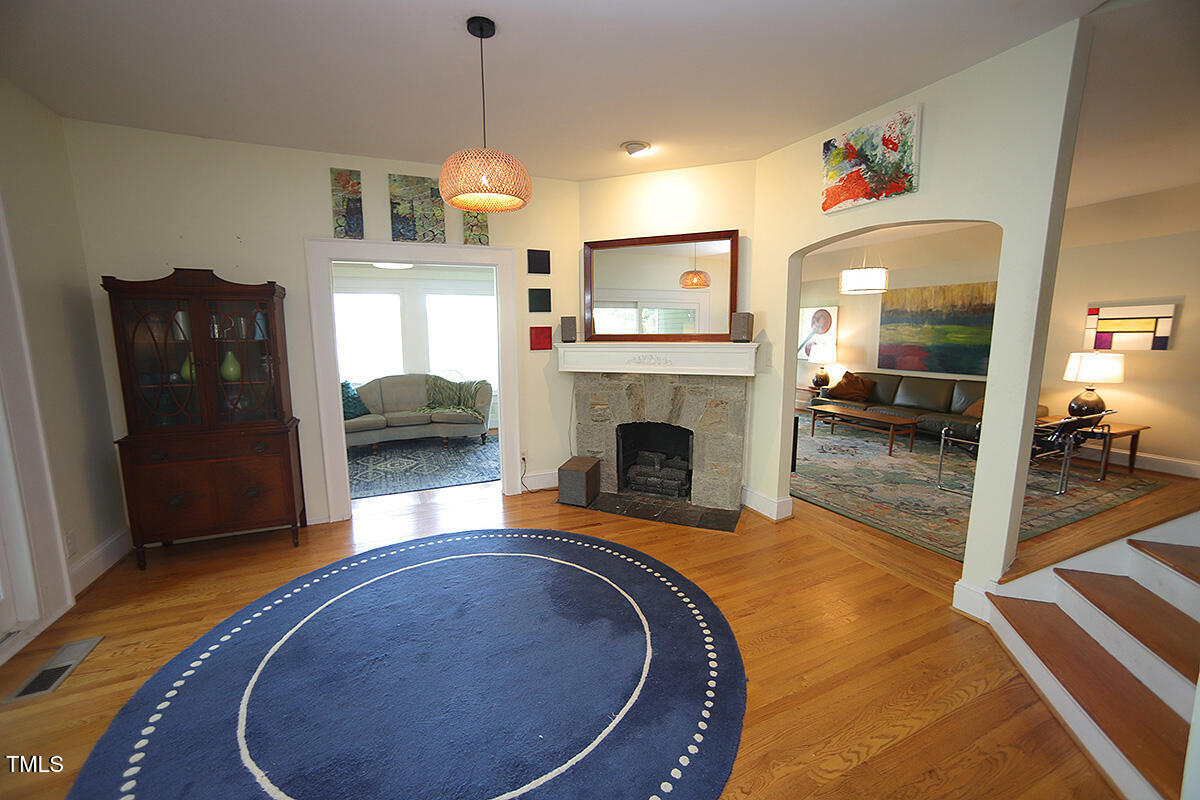3409 White Oak Road Raleigh, NC 27609 - Photo 3 of 24 a view of a livingroom with furniture a fireplace wooden floor and chandelier