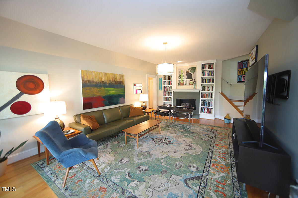3409 White Oak Road Raleigh, NC 27609 - Photo 4 of 24 a living room with furniture a flat screen tv and a fireplace