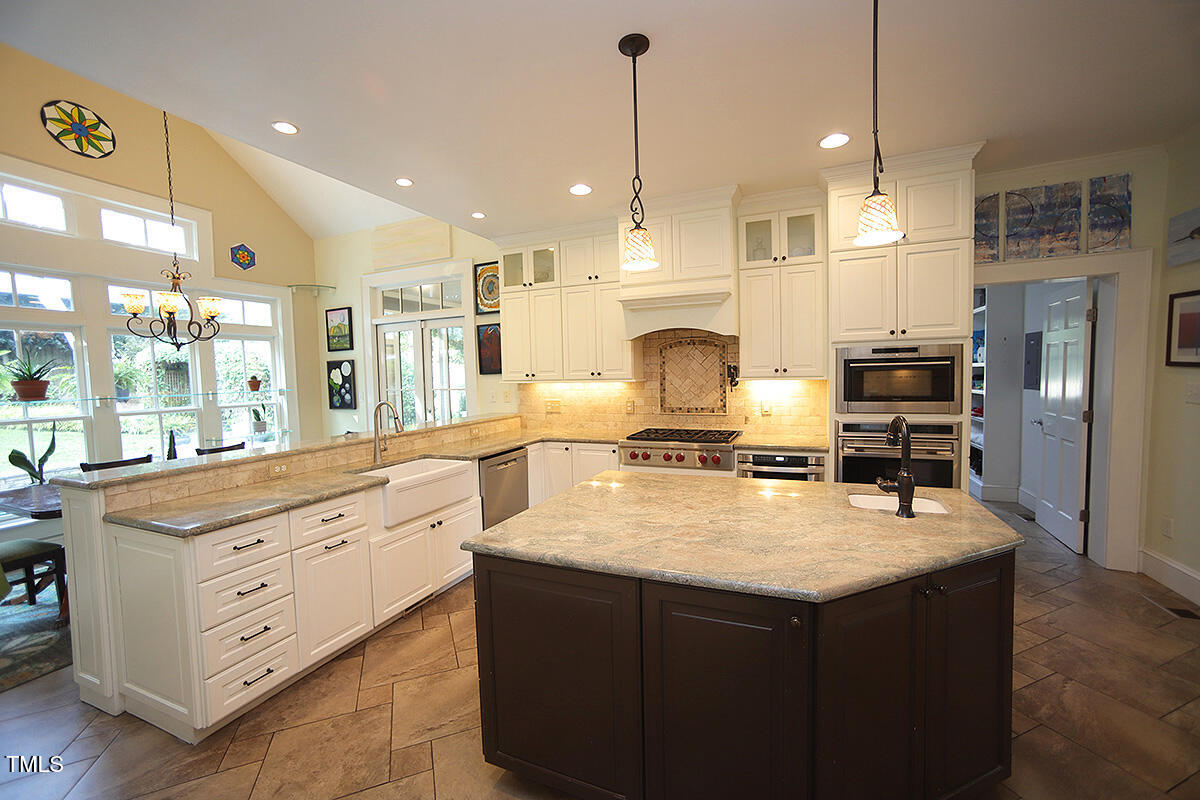 3409 White Oak Road Raleigh, NC 27609 - Photo 8 of 24 a large kitchen with kitchen island a stove a sink a oven and a refrigerator