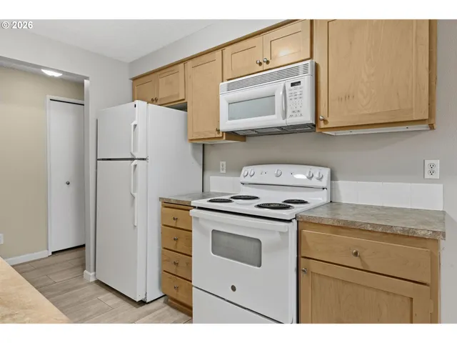 a kitchen with stainless steel appliances white cabinets and a refrigerator