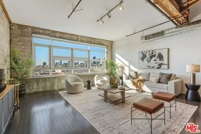 a living room with couches a table and a potted plant
