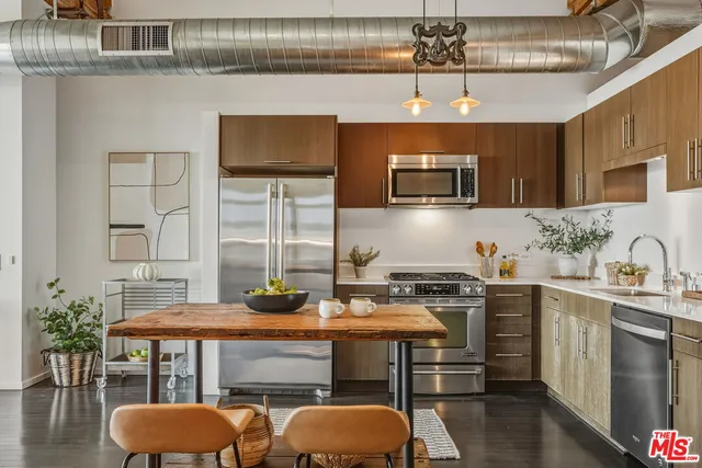 a bedroom with a bed a mirror on dresser and a wooden floor