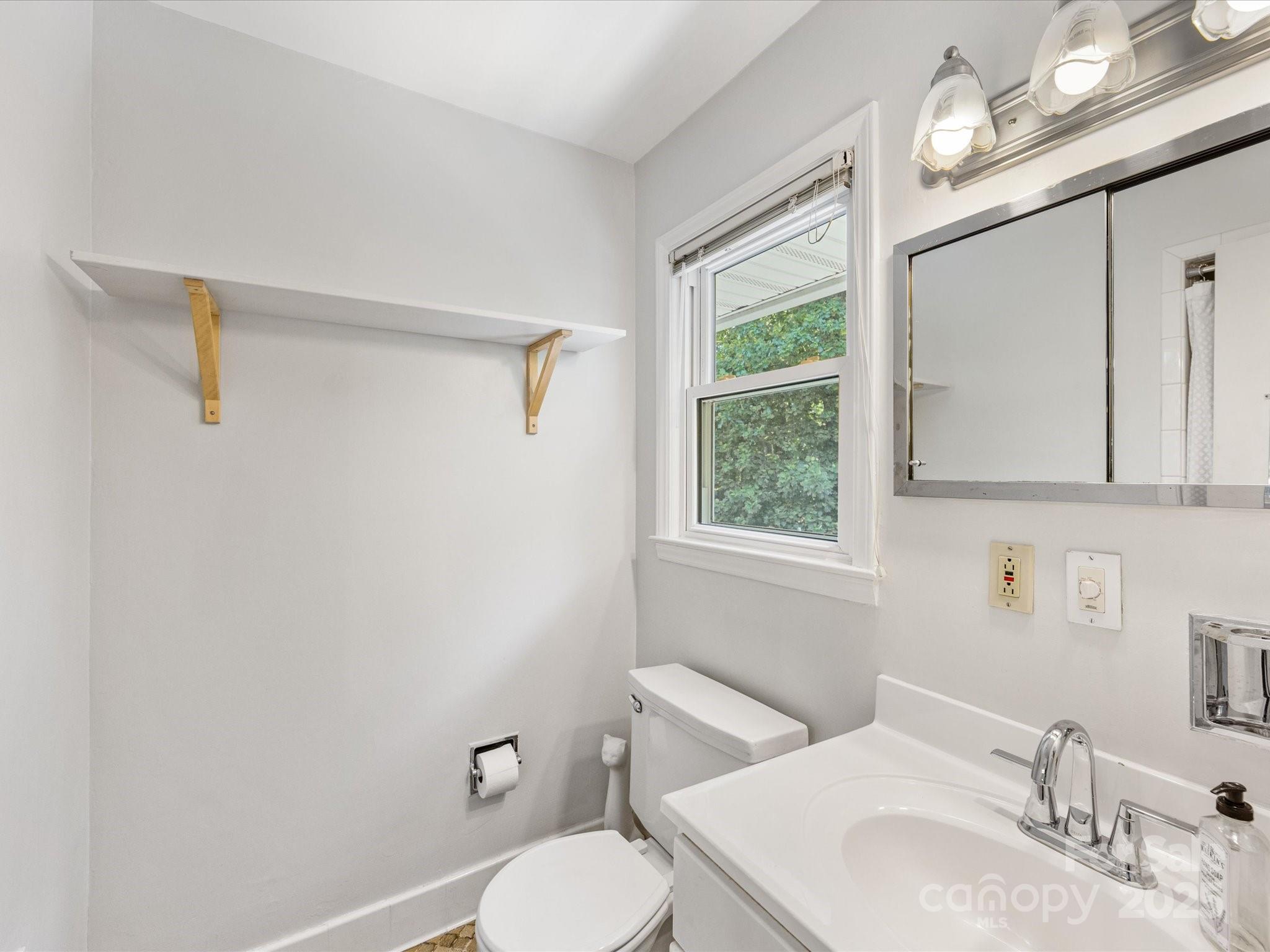 3200 Spring Valley Road Charlotte, NC 28210 - Photo 22 of 45 a bathroom with a sink a mirror and a toilet