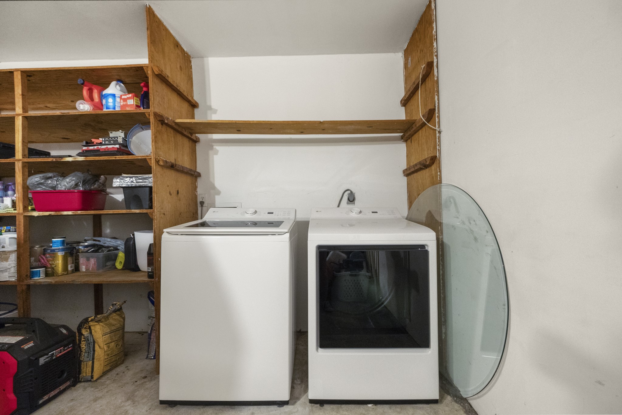 23826 Lestergate Drive Spring, TX 77373 - Photo 29 of 45 Before heading outside, the garage also handles laundry duty with washer and dryer connections set along one wall and shelving nearby for added storage. It’s a practical setup that keeps everyday chores tucked away from the main living spaces.