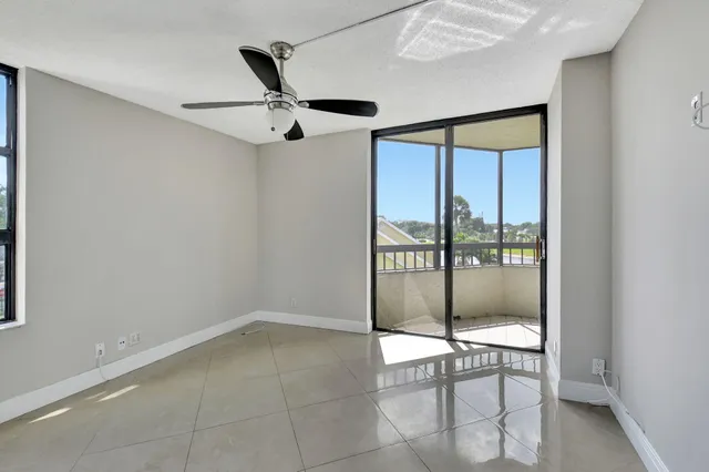 a view of empty room with cabinet and ceiling fan