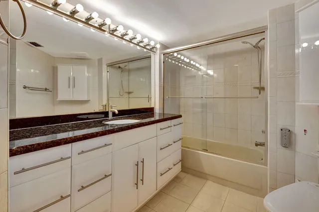 a bathroom with a granite countertop shower mirror and a sink