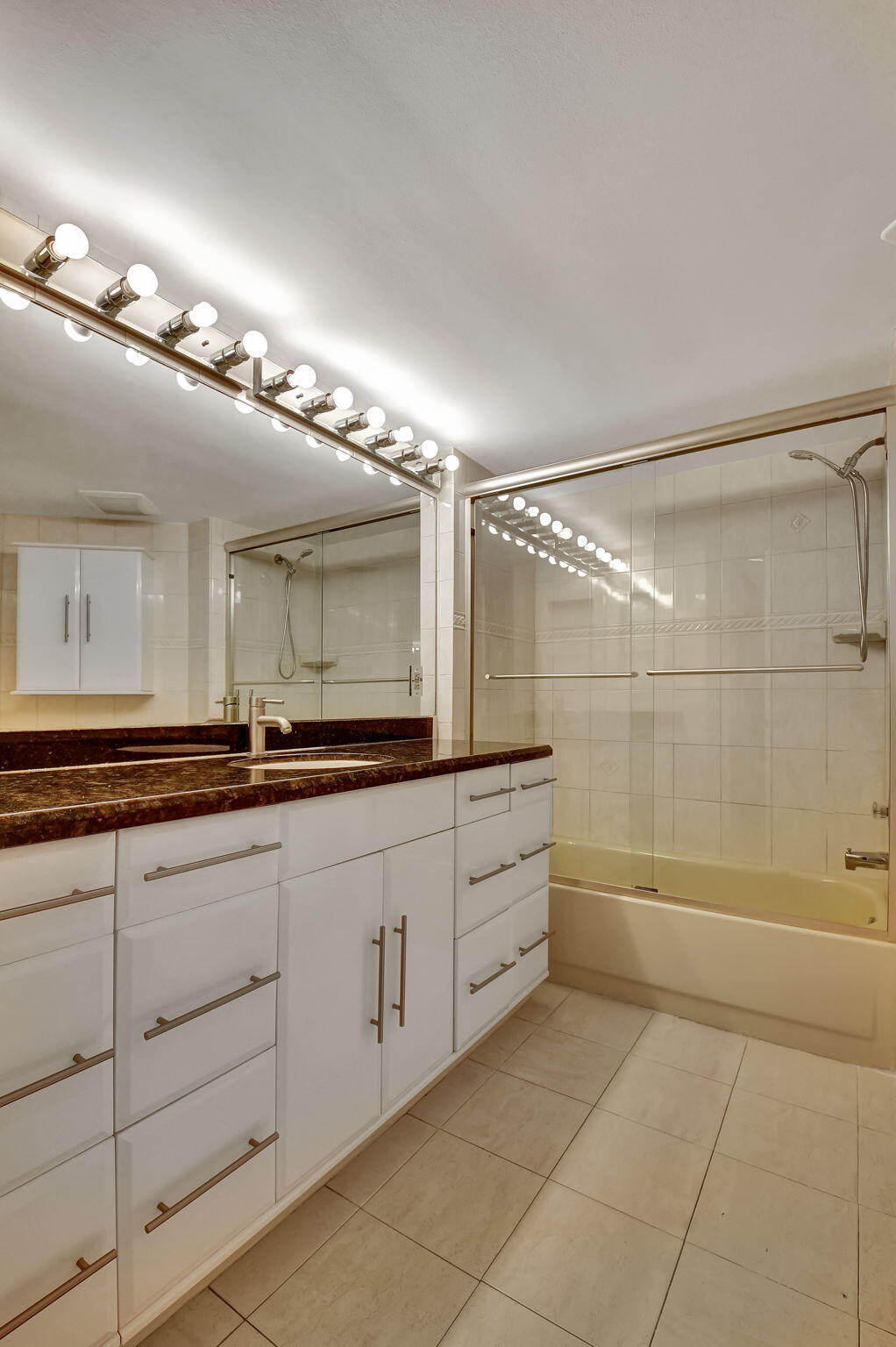 6372 La Costa Drive, Unit 302 Boca Raton, FL 33433 - Photo 36 of 52 a bathroom with a double vanity sink a large mirror and shower