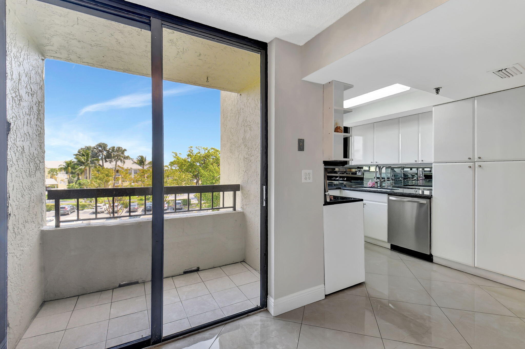 6372 La Costa Drive, Unit 302 Boca Raton, FL 33433 - Photo 9 of 52 a kitchen with white cabinets and window