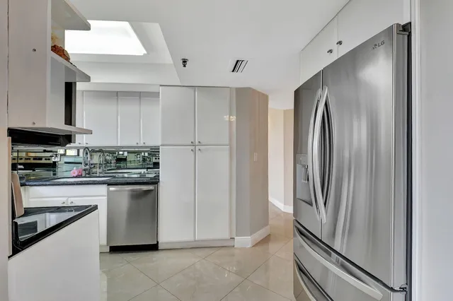 a kitchen with stainless steel appliances granite countertop a refrigerator and a stove