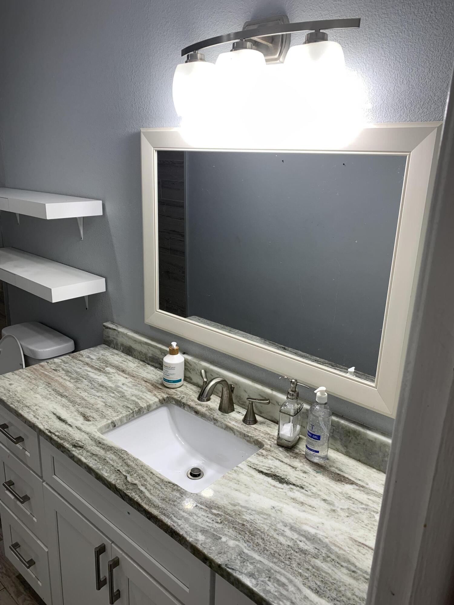 1156 Block Island Road Wellington, FL 33414 - Photo 13 of 15 a bathroom with a granite countertop sink and a mirror