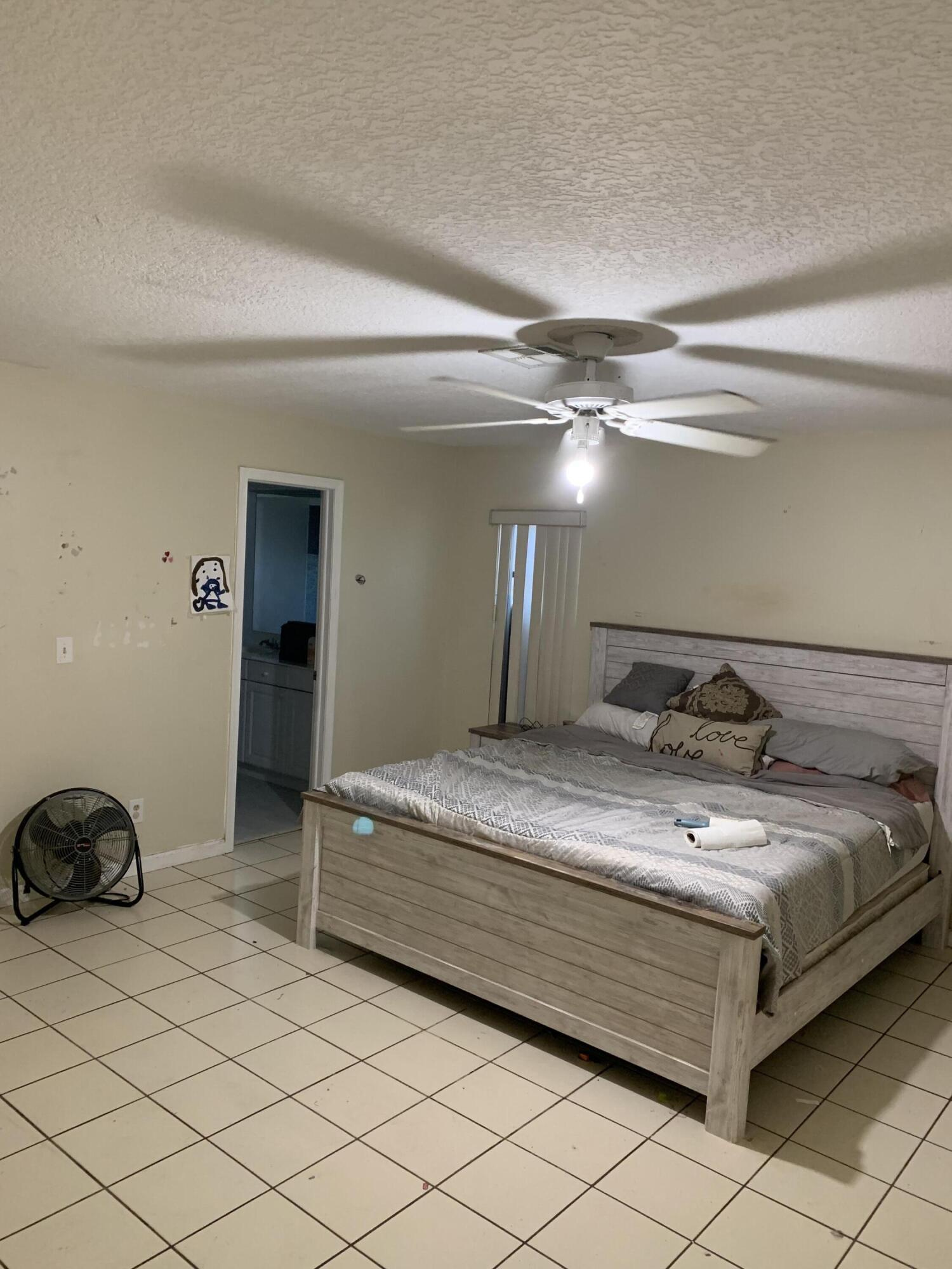 1156 Block Island Road Wellington, FL 33414 - Photo 6 of 15 a bedroom with a bed and lamp