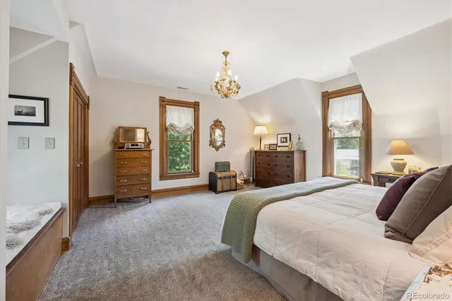 a bedroom with a large bed and a chandelier