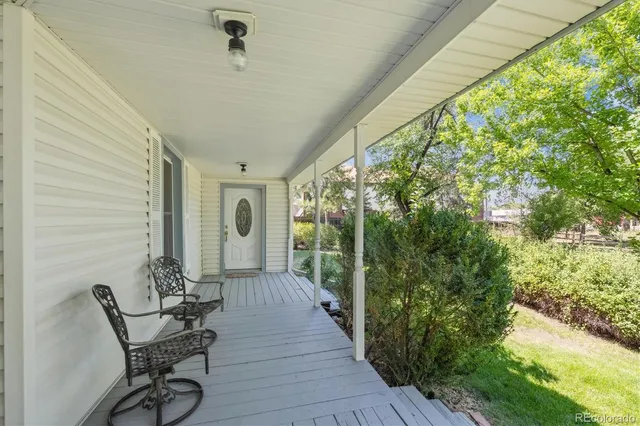 a view of a porch with furniture and a yard