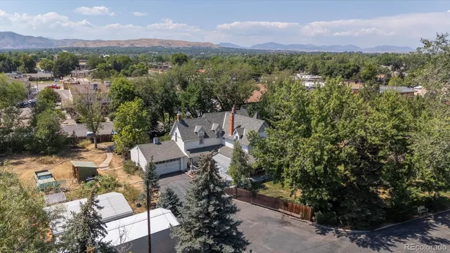 an aerial view of a houses with a street and green space