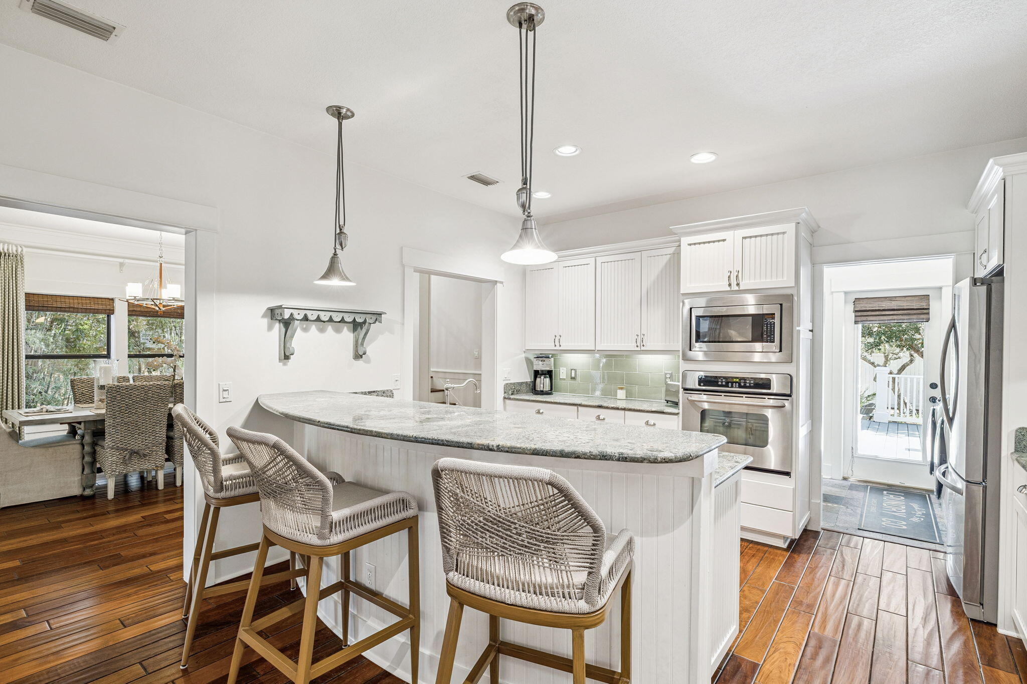 76 Crescent Road Santa Rosa Beach, FL 32459 - Photo 26 of 104 a kitchen with stainless steel appliances kitchen island granite countertop a table chairs and wooden floor