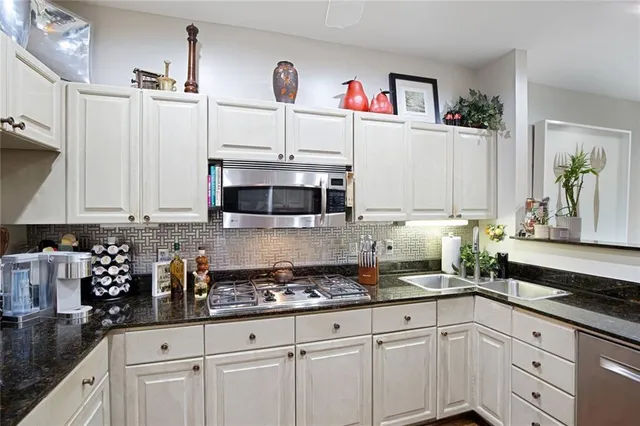 a kitchen with stainless steel appliances granite countertop a refrigerator and a stove top oven