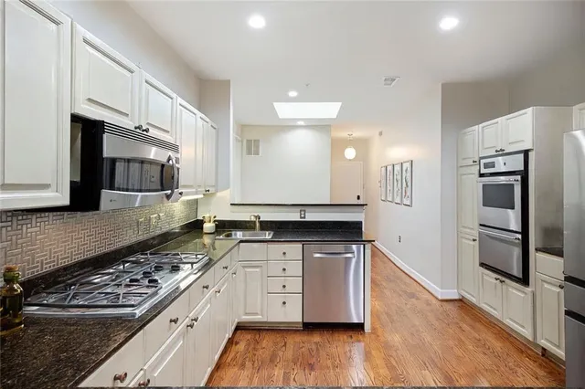 a kitchen with stainless steel appliances a sink stove and refrigerator