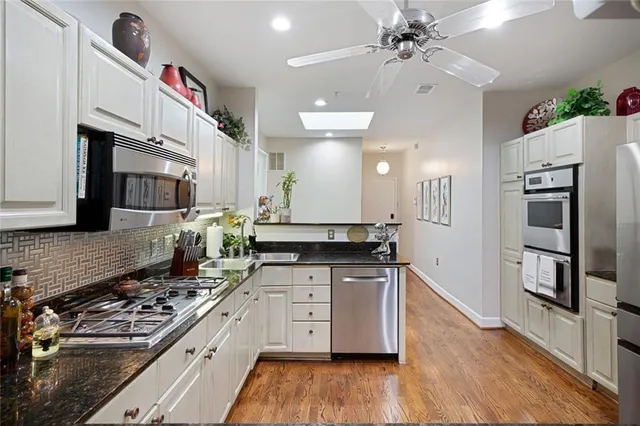 a kitchen with granite countertop white cabinets and white appliances