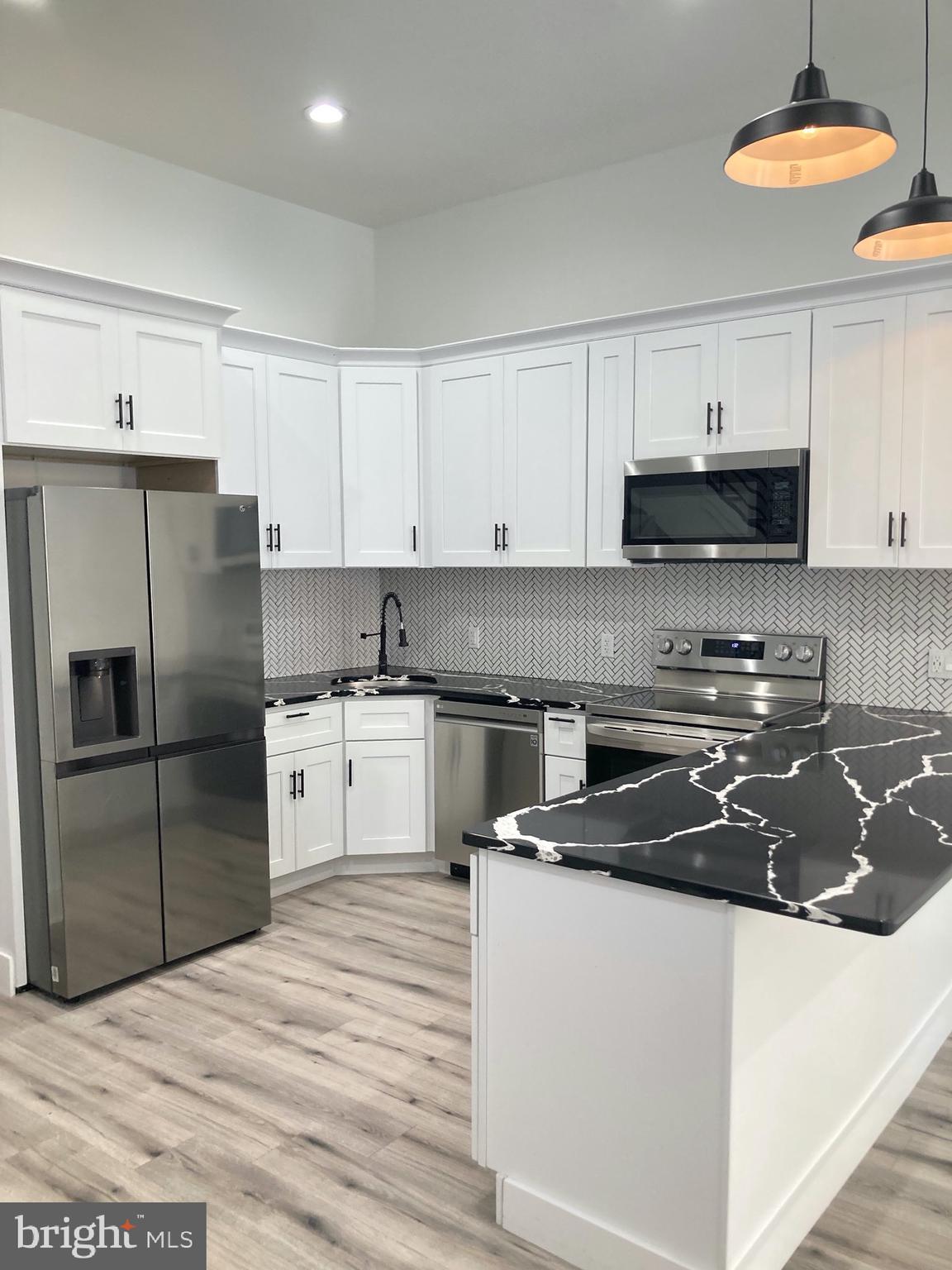 1830 West Diamond Street, Unit 1 Philadelphia, PA 19121 - Photo 1 of 17 a kitchen with a refrigerator sink and white cabinets