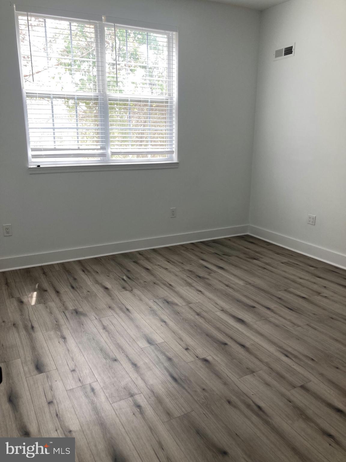 1830 West Diamond Street, Unit 1 Philadelphia, PA 19121 - Photo 12 of 17 an empty room with wooden floor and windows