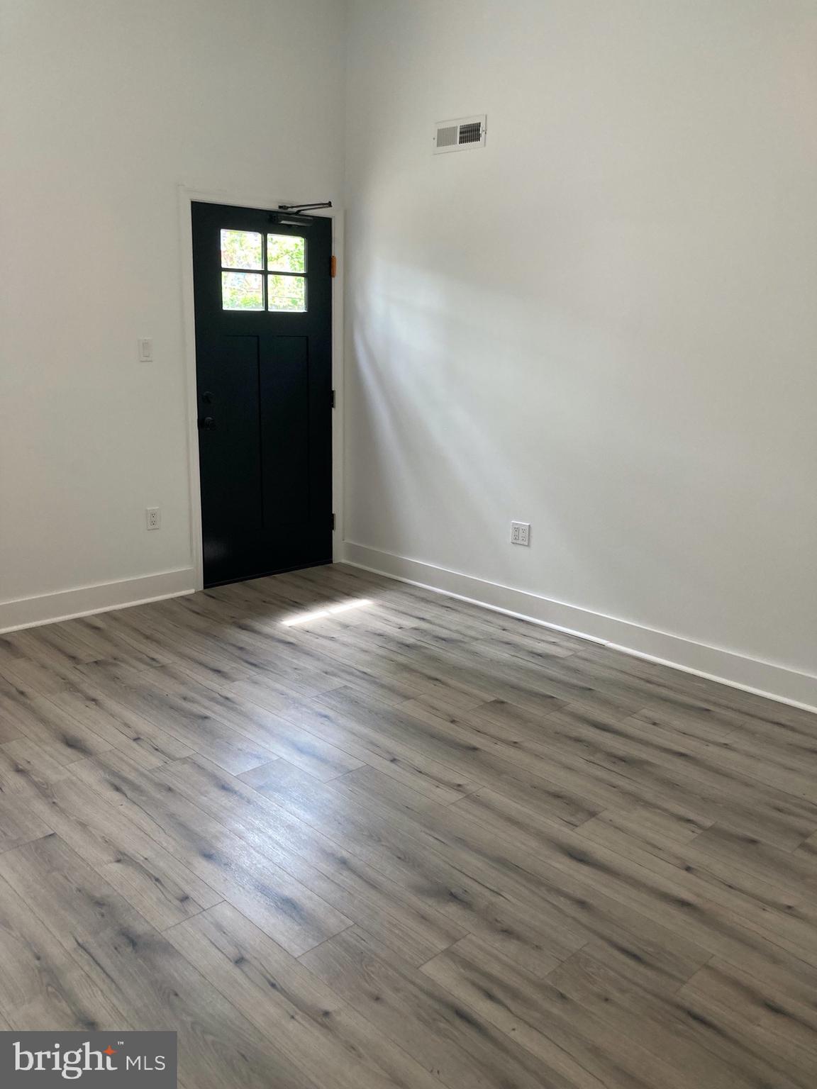 1830 West Diamond Street, Unit 1 Philadelphia, PA 19121 - Photo 13 of 17 a view of an empty room with wooden floor and a window