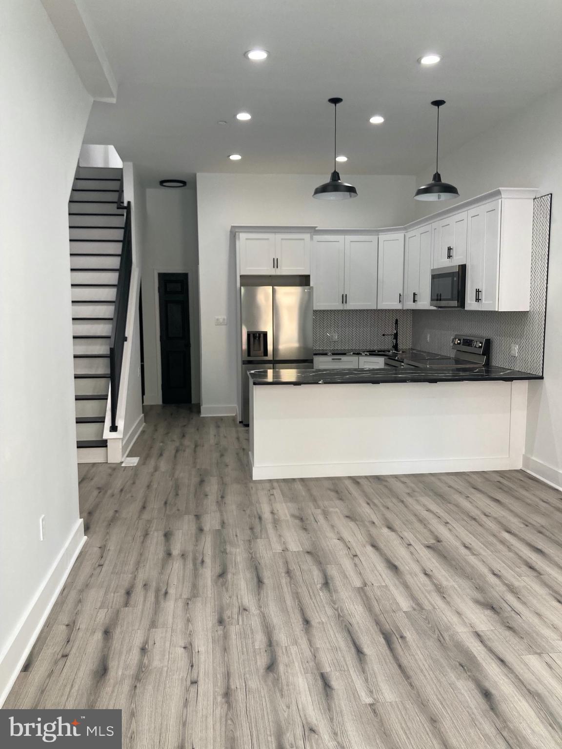 1830 West Diamond Street, Unit 1 Philadelphia, PA 19121 - Photo 2 of 17 an empty room with wooden floor and kitchen view