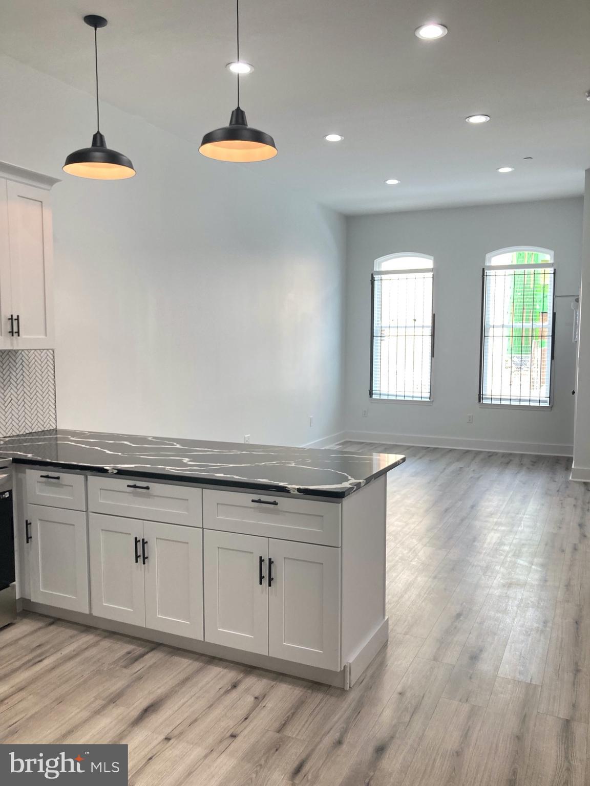 1830 West Diamond Street, Unit 1 Philadelphia, PA 19121 - Photo 3 of 17 a kitchen with granite countertop a stove a sink and a wooden floors