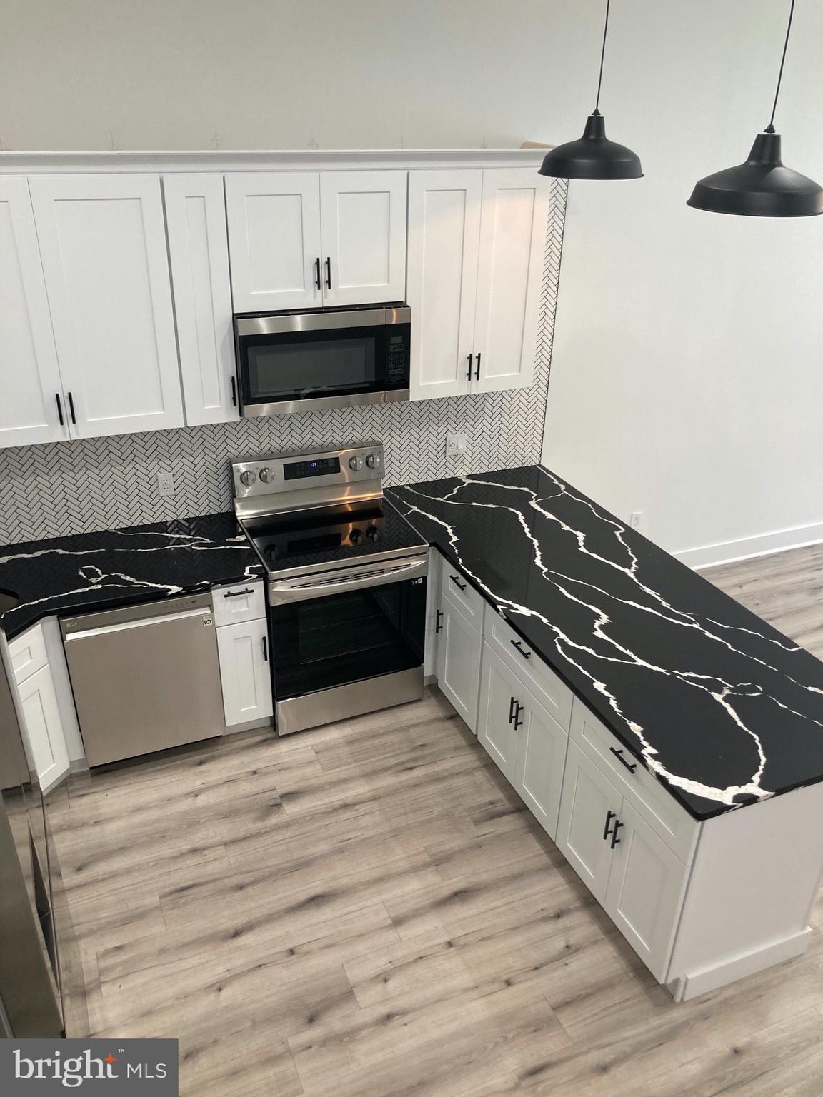 1830 West Diamond Street, Unit 1 Philadelphia, PA 19121 - Photo 4 of 17 a kitchen with granite countertop a stove and a microwave